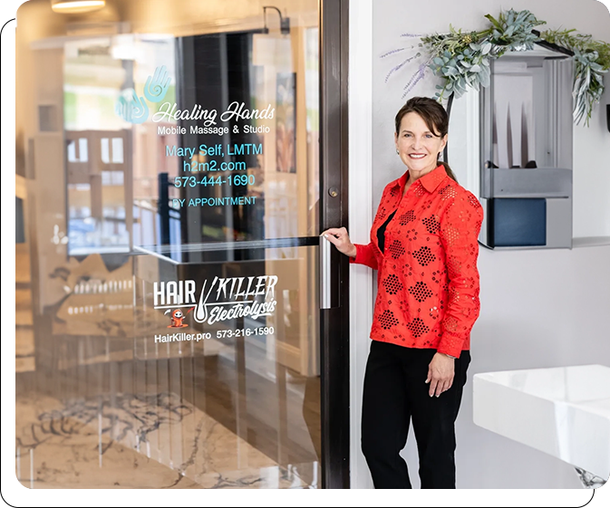 A woman in red jacket standing outside of store.